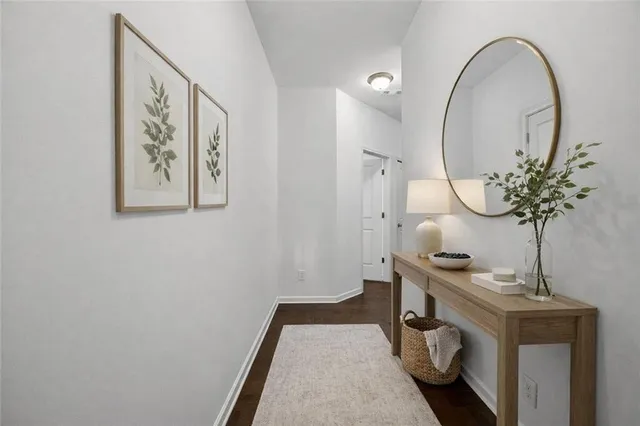 a view of a hallway with wooden floor and a bathroom