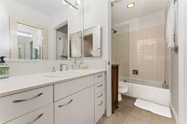 a bathroom with a sink a toilet a mirror and shower