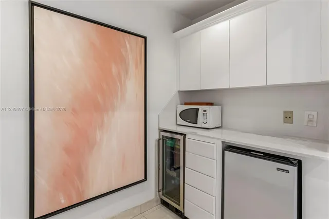 a kitchen with a white cabinets and a refrigerator