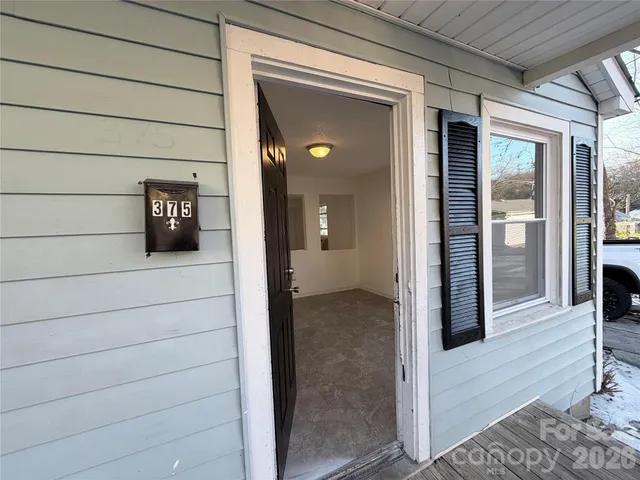 a view of a hallway with wooden floor and a cabinet
