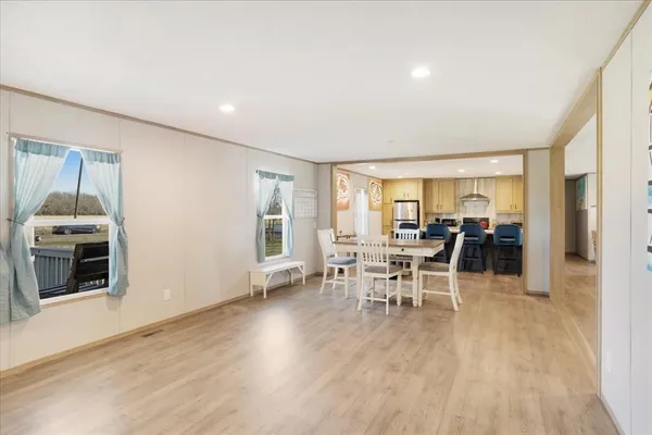 a large living room with stainless steel appliances granite countertop a sink a table and chairs