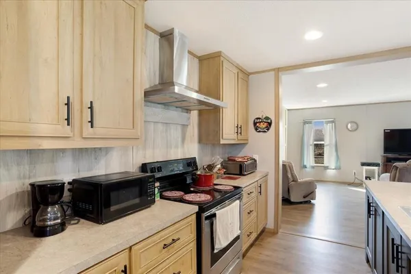 a open kitchen with stainless steel appliances granite countertop a center island a table and a refrigerator