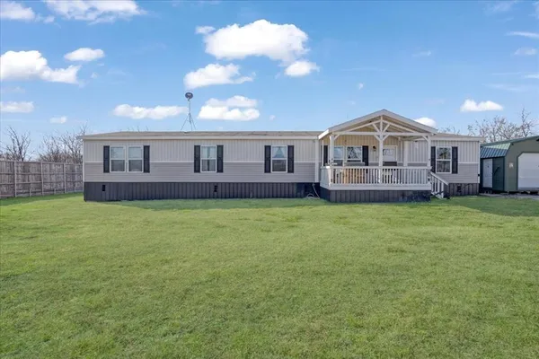 a front view of a house with a garden and yard