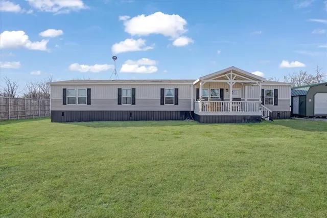 a front view of a house with a garden and yard