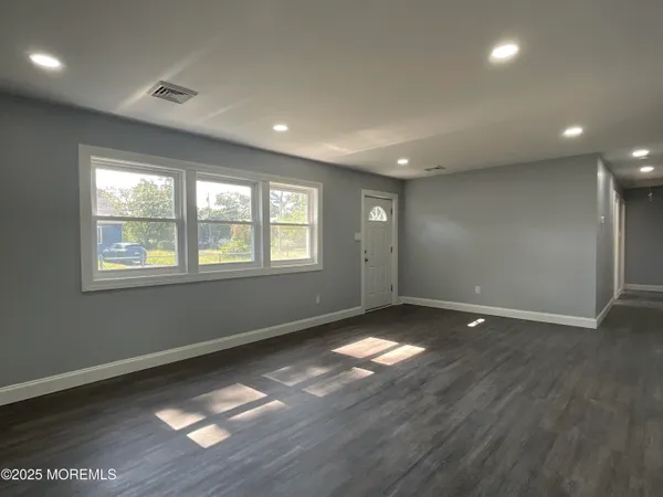 a large kitchen with a window and stainless steel appliances