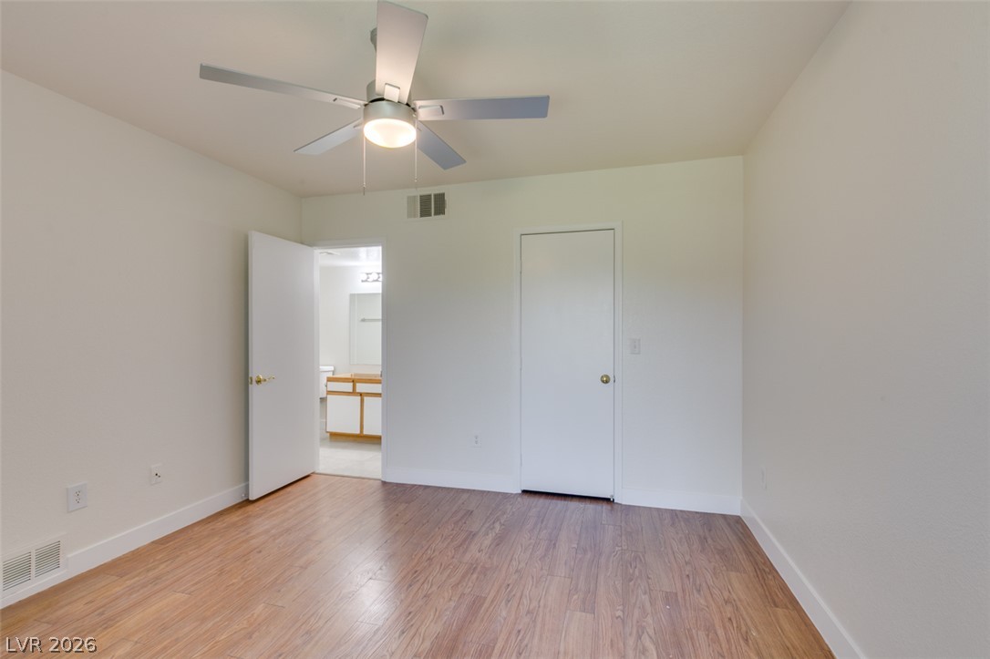 6650 West Warm Springs Road, Unit 2118 Las Vegas, NV 89118 - Photo 20 of 41 A well-lit bedroom features durable laminate flooring and a ceiling fan for comfort.