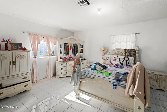 a bedroom with furniture a flat tv screen and dresser