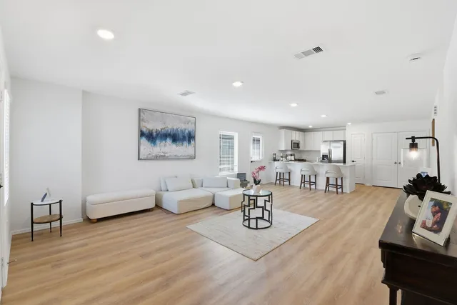 a living room with furniture and wooden floor