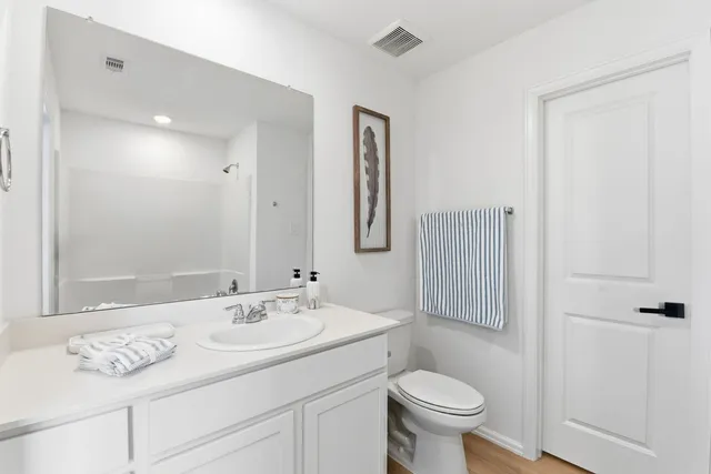 a kitchen with stainless steel appliances a table chairs refrigerator and cabinets