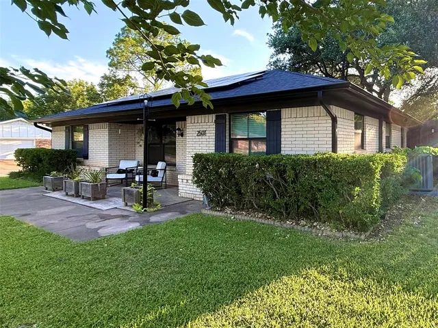 a front view of a house with patio and garden