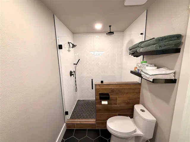 a bathroom with a toilet and a shower