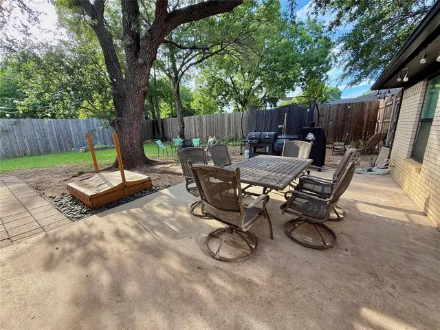 a view of a backyard with a table and chairs