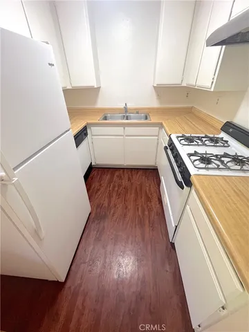 a kitchen with a sink and wooden floor