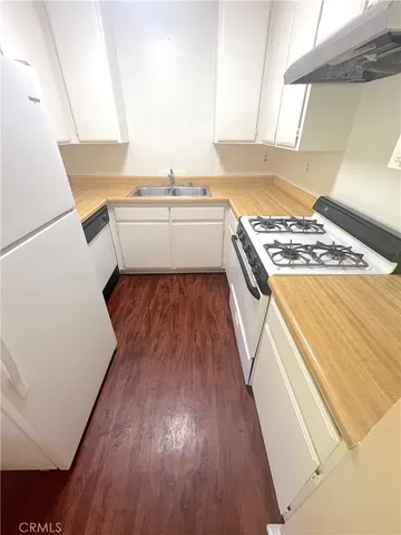 a kitchen with a sink and wooden floor