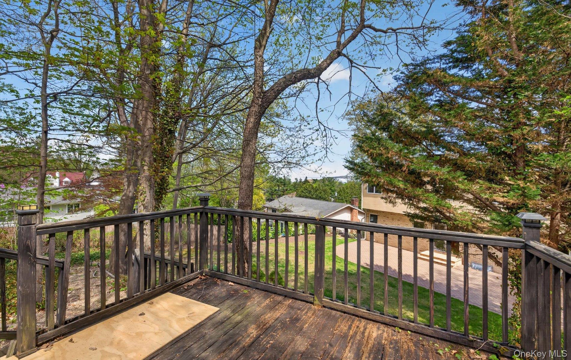 16 East Slope Road Bayville, NY 11709 - Photo 37 of 48 Elevated wooden deck featuring railing with balusters and a distant neighborhood backdrop