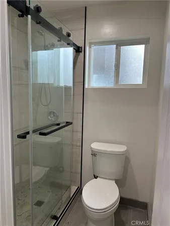a white toilet sitting next to a shower