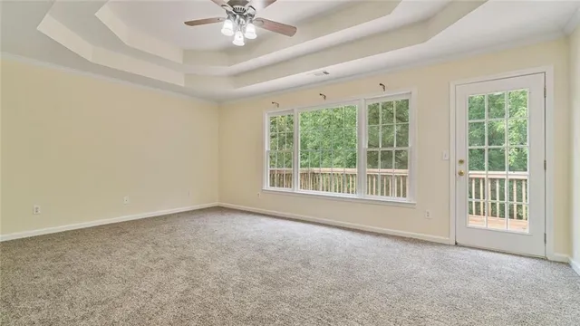 an empty room with chandelier and windows