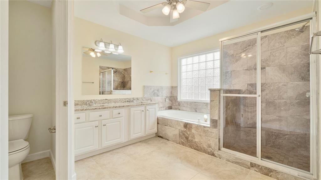 4612 Springside Court Southwest Mableton, GA 30126 - Photo 18 of 40 a bathroom with a granite countertop sink a toilet and a shower