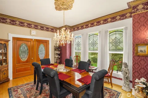 a view of a dining room with furniture a chandelier and wooden floor