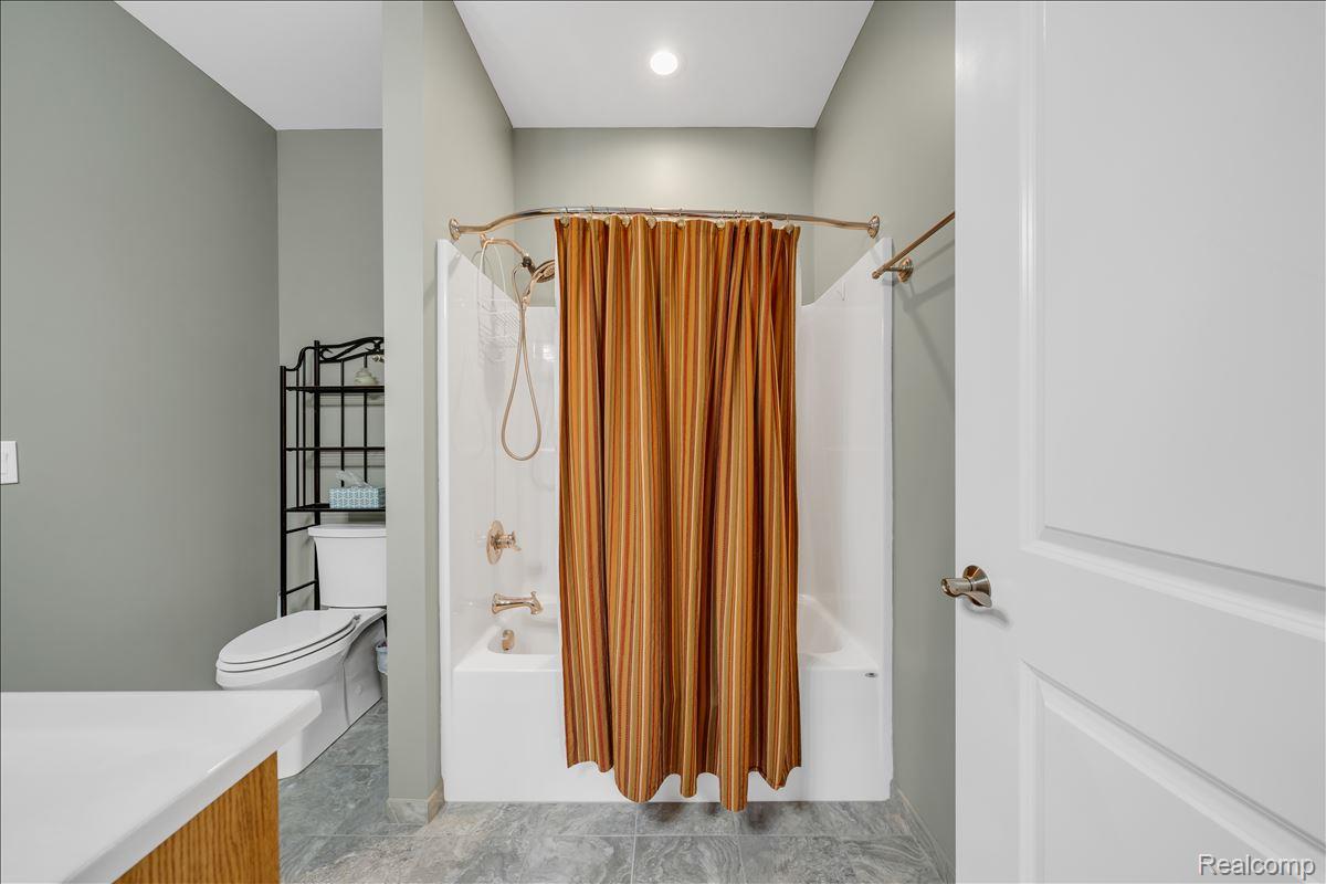 4266 McCandlish Road Grand Blanc, MI 48439 - Photo 35 of 68 Bathroom featuring a white bathtub, brushed nickel fixtures, a white toilet, and gray wall paint