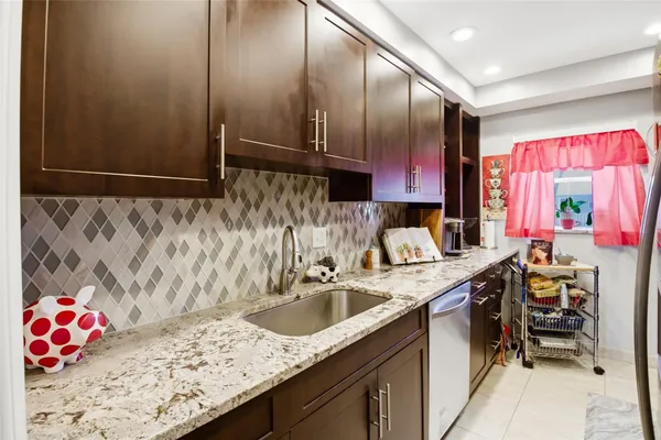 a kitchen with a sink refrigerator and cabinets