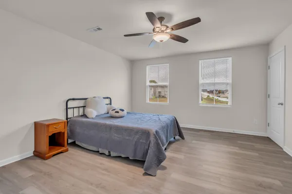 a spacious bedroom with a bed and a ceiling fan