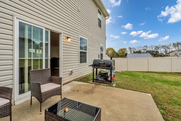 a view of a two chairs in the back yard of the house