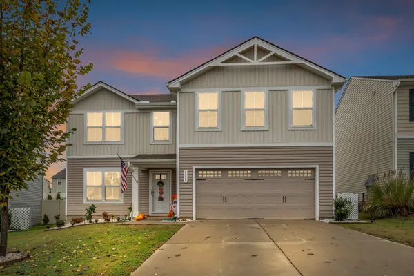 a front view of a house with a yard and garage