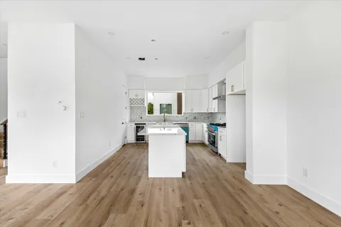 a view of a kitchen with wooden floor and a ceiling fan