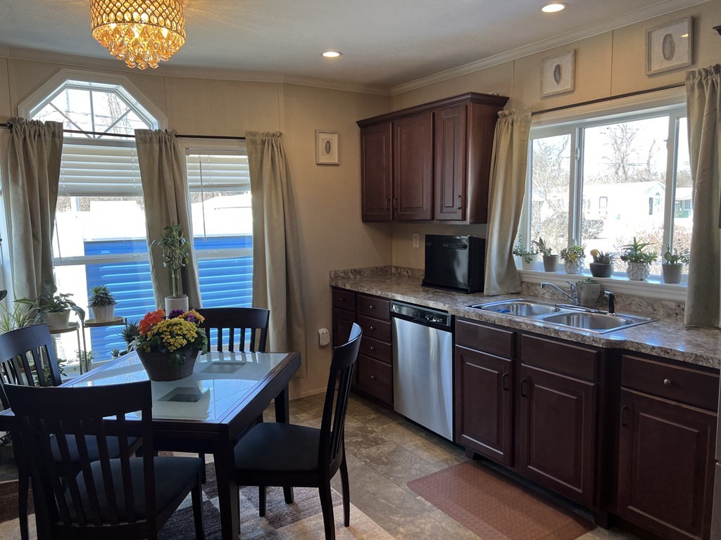28 Grappone Drive Concord, NH 03301 - Photo 4 of 20 a kitchen with stainless steel appliances granite countertop a stove a sink dishwasher a dining table and chair with wooden floor