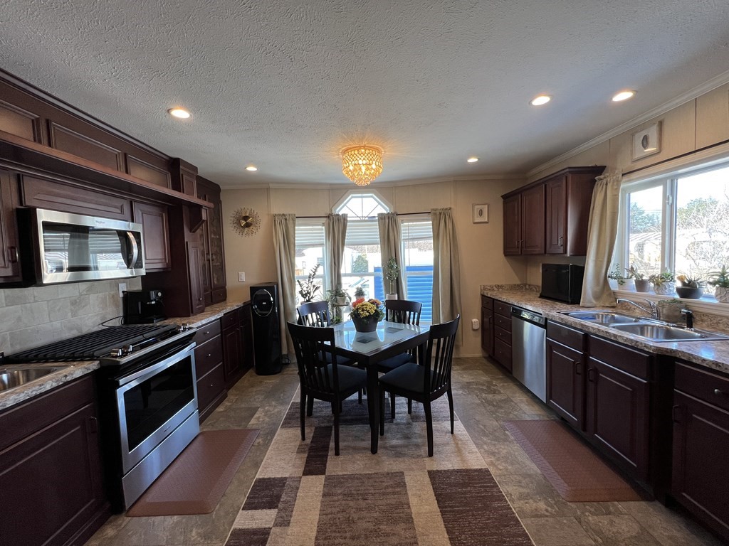 28 Grappone Drive Concord, NH 03301 - Photo 8 of 20 a kitchen with stainless steel appliances granite countertop wooden cabinets a stove top oven and a granite counter tops