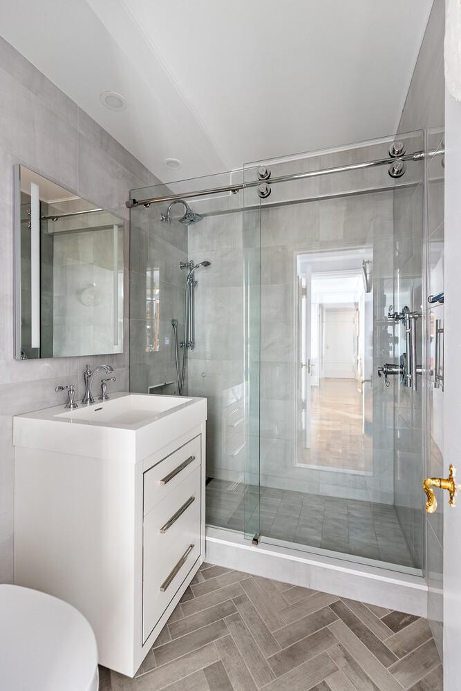 45 Sutton Place South, Unit 10H Manhattan, NY 10022 - Photo 17 of 18 a bathroom with a sink a toilet and shower