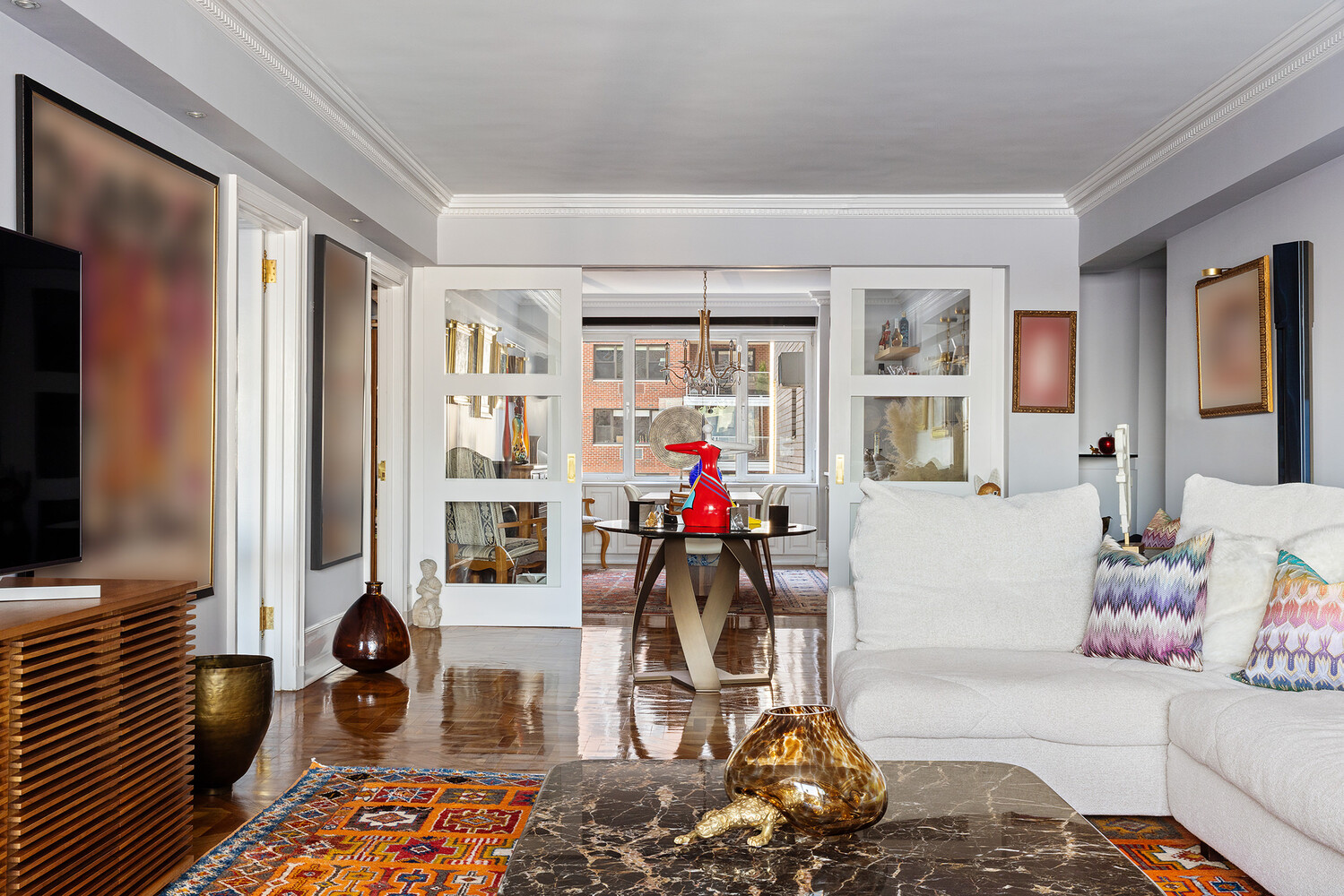 45 Sutton Place South, Unit 10H Manhattan, NY 10022 - Photo 3 of 18 a living room with furniture and a flat screen tv