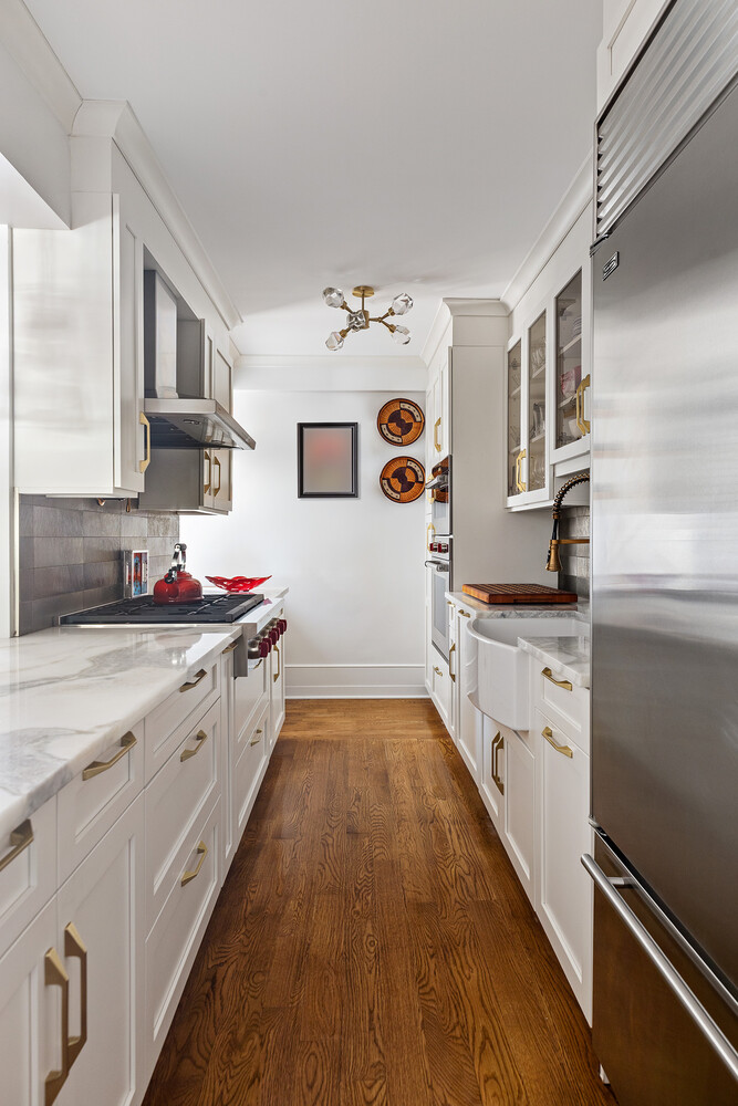 45 Sutton Place South, Unit 10H Manhattan, NY 10022 - Photo 8 of 18 a large white kitchen with stainless steel appliances granite countertop a lot of counter top space