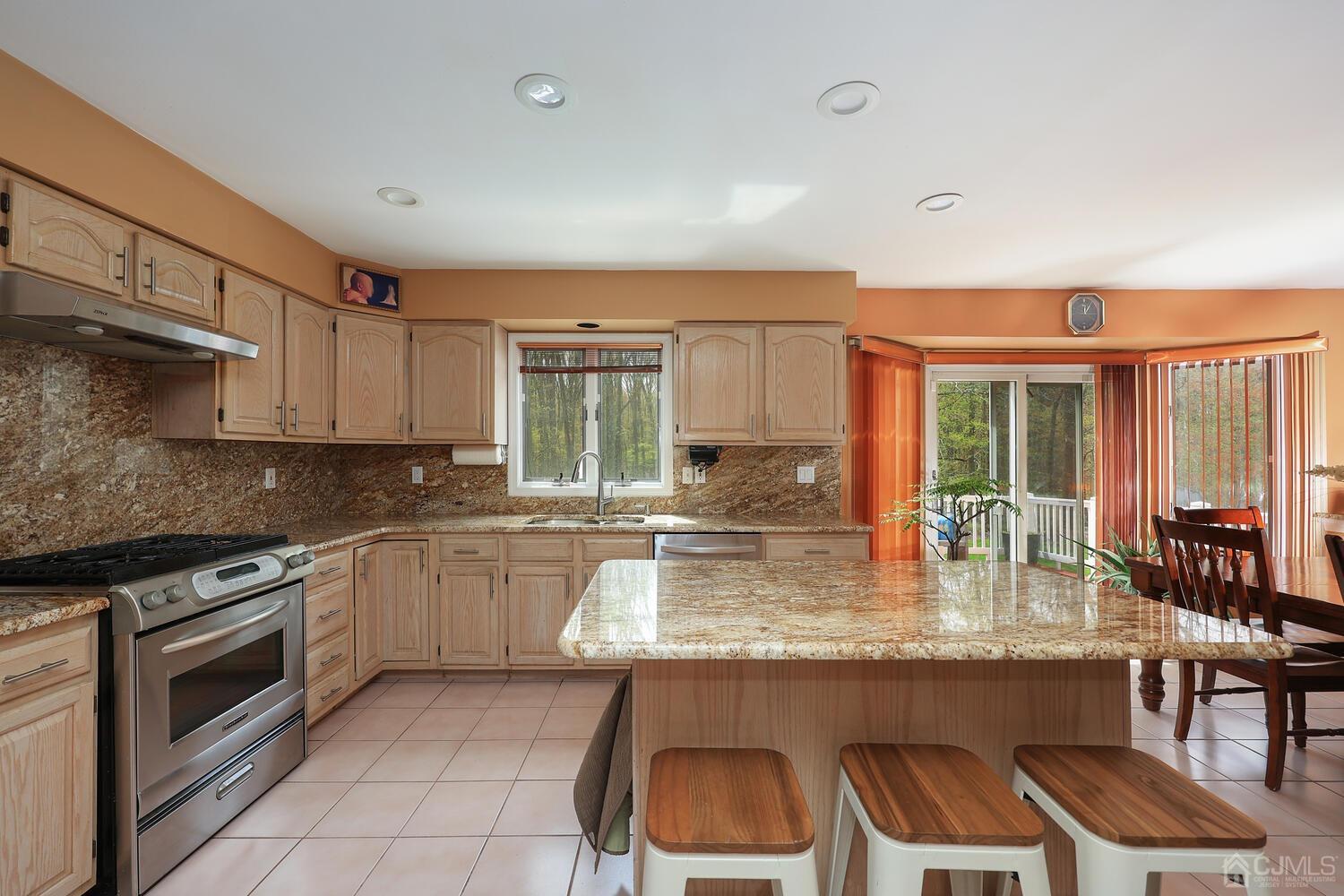 861 New Dover Road Edison, NJ 08820 - Photo 16 of 53 a kitchen with granite countertop a stove chairs and granite counter tops