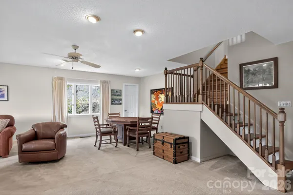 a living room with furniture and a dining table with windows