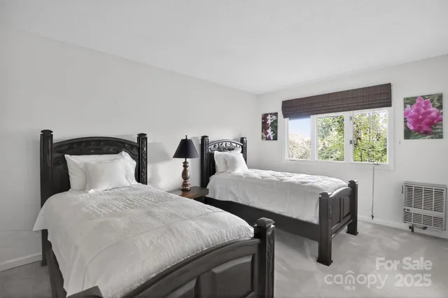 a bedroom with two beds and a window