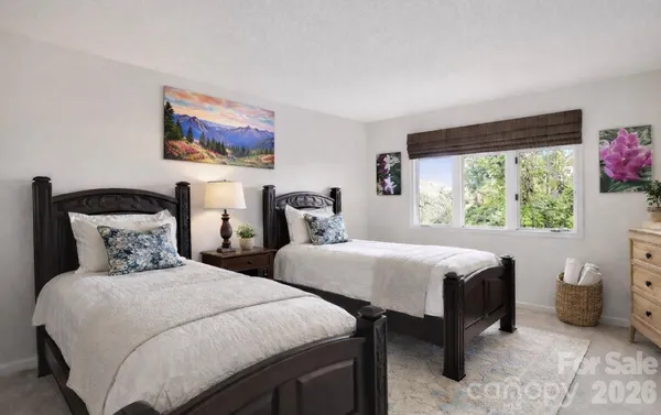 a bedroom with two beds and a large window