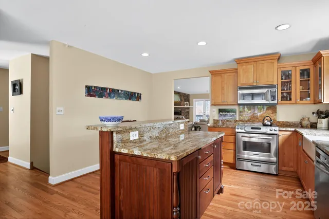 a kitchen with stainless steel appliances granite countertop a stove a sink dishwasher and a refrigerator