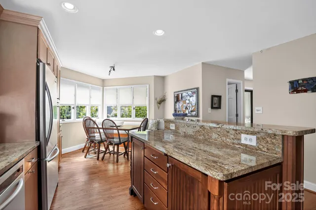 a dining table with chairs and kitchen view