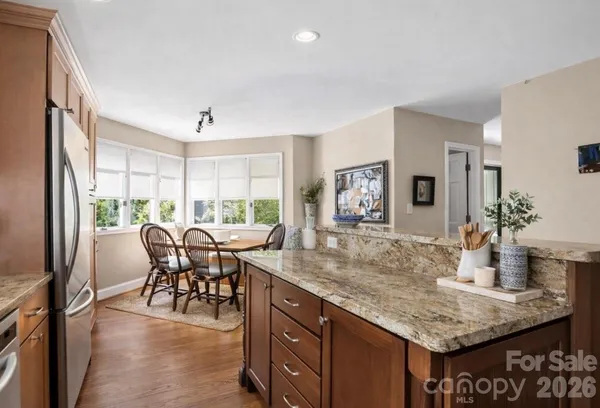 a dining room with furniture a rug a potted plant and a chandelier