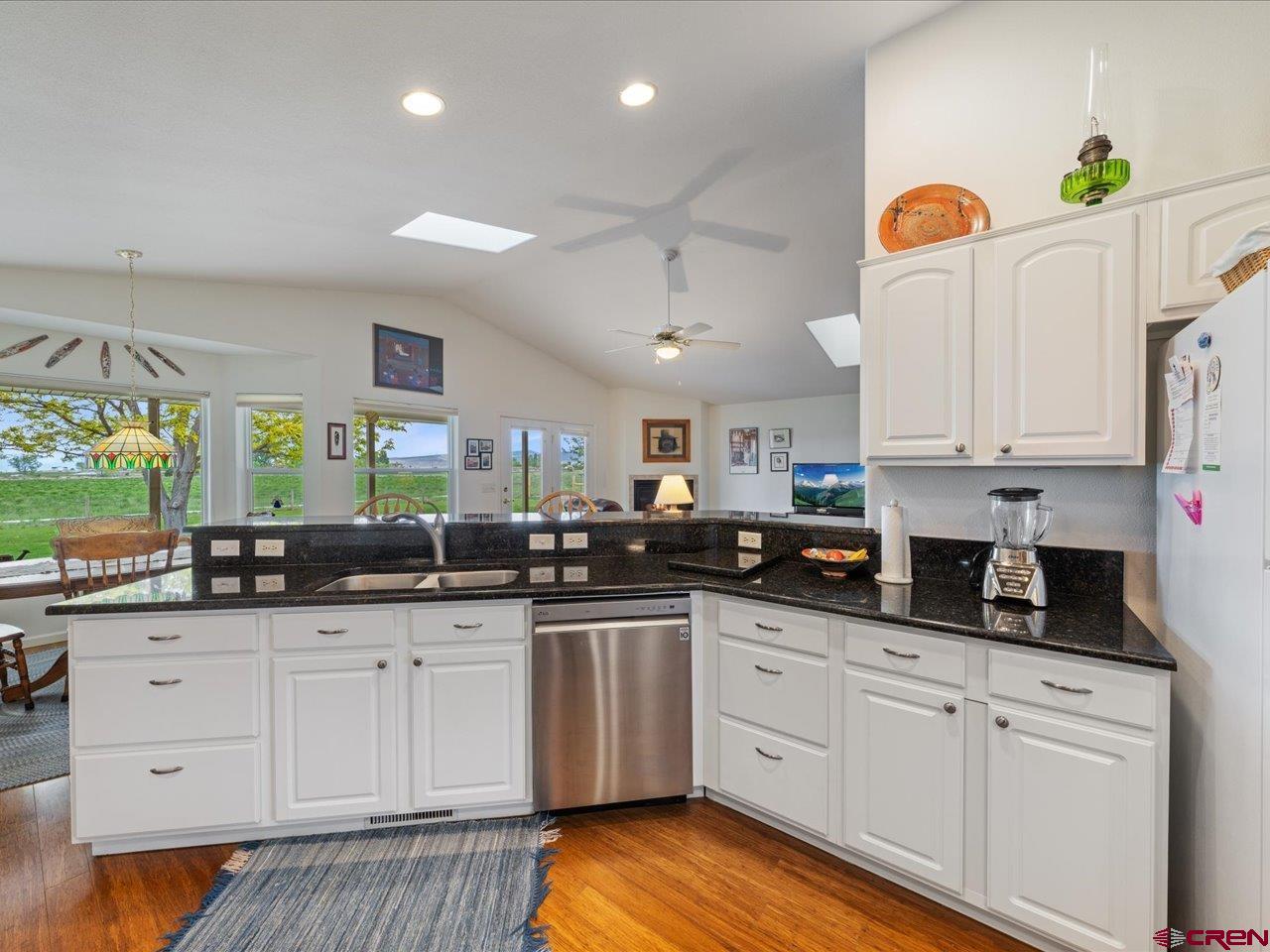 61611 Monroe Road Montrose, CO 81403 - Photo 12 of 35 a kitchen with granite countertop a sink cabinets stainless steel appliances and a window