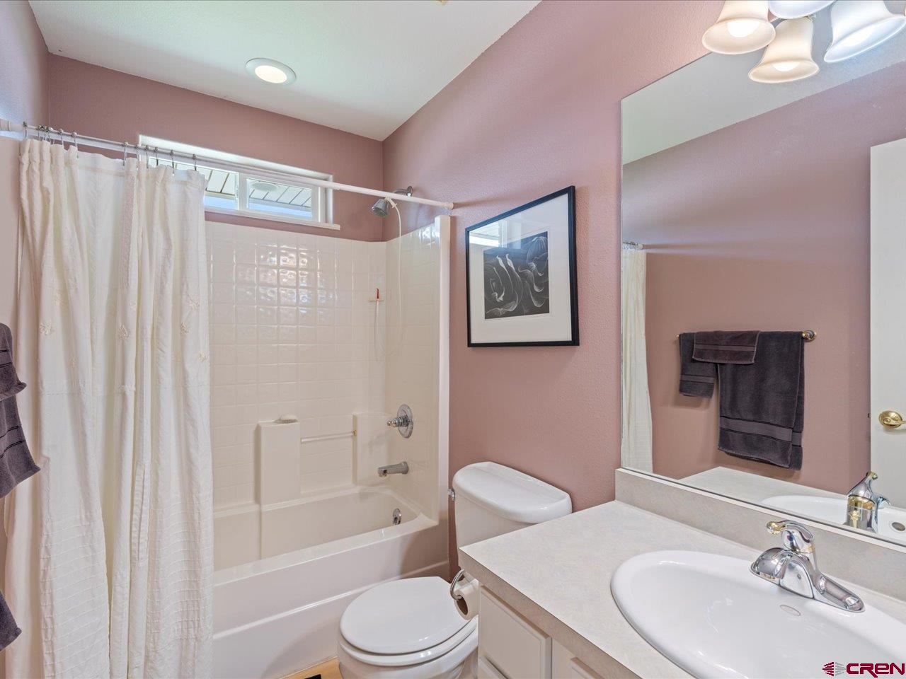 61611 Monroe Road Montrose, CO 81403 - Photo 23 of 35 a bathroom with a sink a toilet a mirror a vanity and bathtub