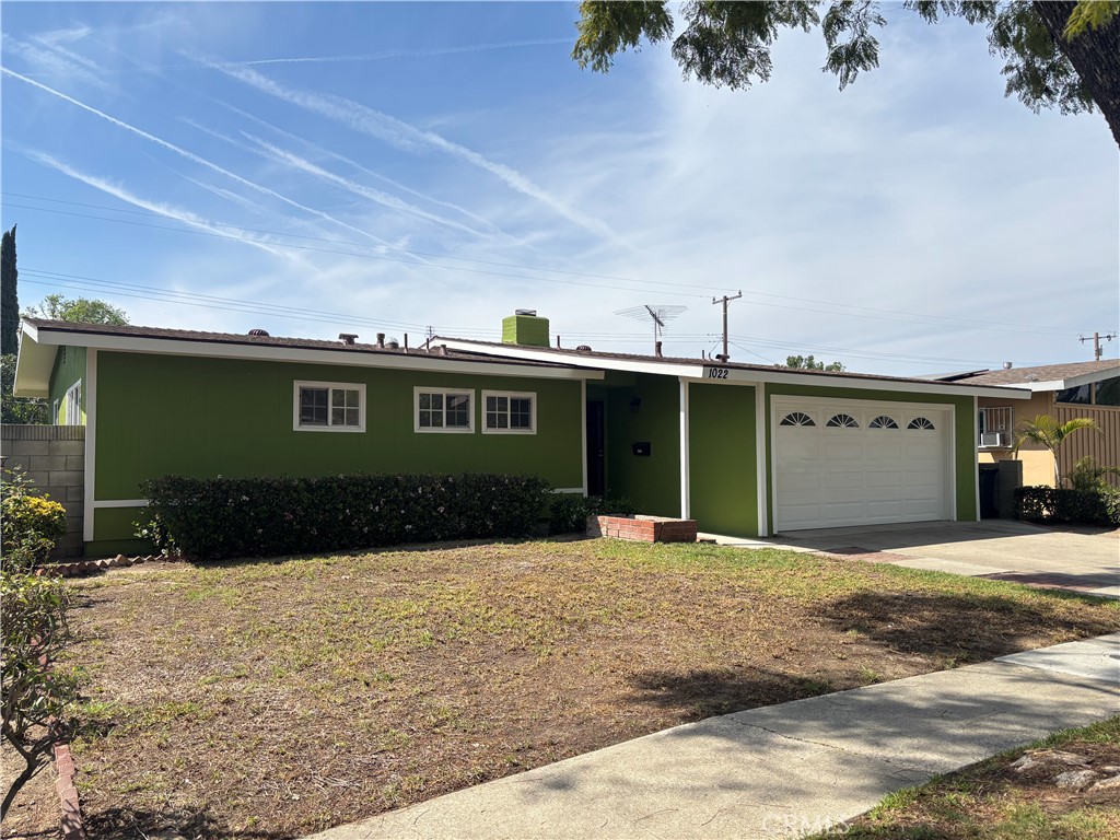 1022 Concord Street Santa Ana, CA 92701 - Photo 3 of 19 a front view of a house with a yard and garage