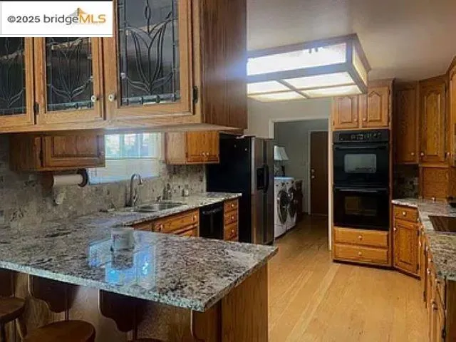 a kitchen with stainless steel appliances granite countertop a sink and a refrigerator