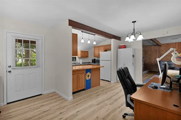 a kitchen with kitchen island a dining table chairs refrigerator and sink