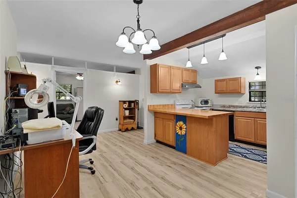 a view of kitchen with sink refrigerator dining table and chairs
