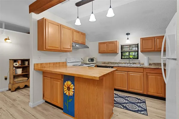 a kitchen with stainless steel appliances granite countertop a sink a stove and a wooden floors