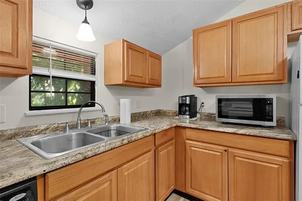 a kitchen with stainless steel appliances granite countertop a sink a window and cabinets