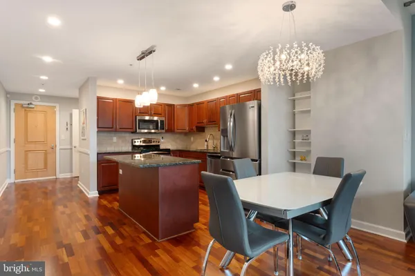 a kitchen with stainless steel appliances granite countertop a refrigerator a stove a sink dishwasher with a dining table and chairs